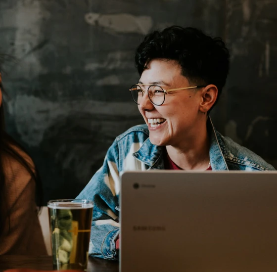 Woman looking to the right with laptop laughing